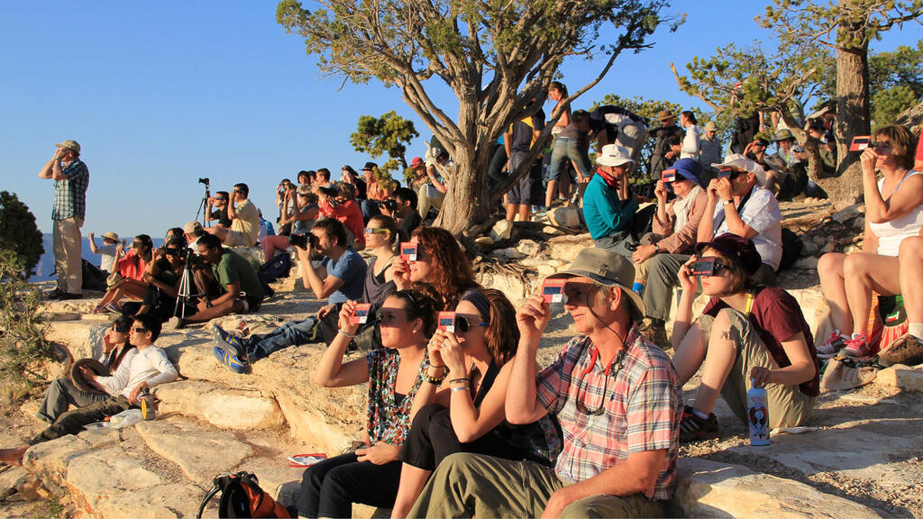 a crowd of people watching an eclipse