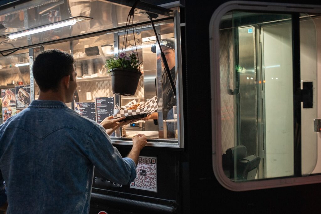 man purchasing a meal from a food truck