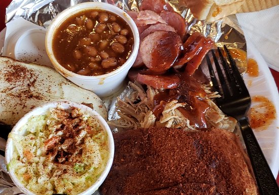 food, coleslaw, baked beans, pork, sausage, a fork