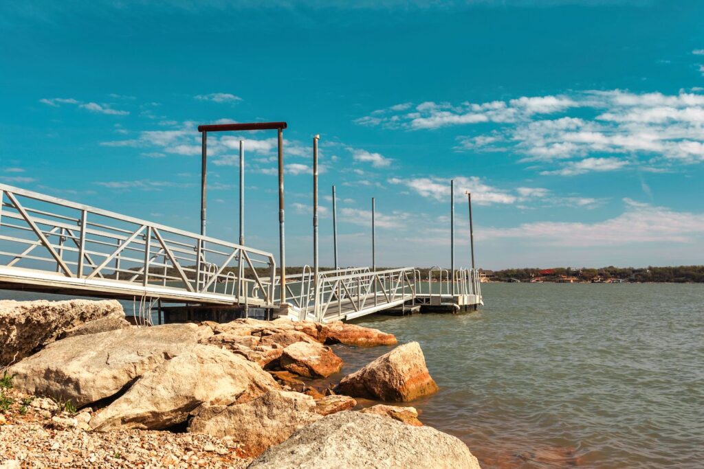Lake with boat dock and rocks on the shoreline. 
