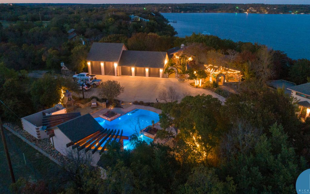 House by lake with string lights and a stunning pool and outdoor space. 
