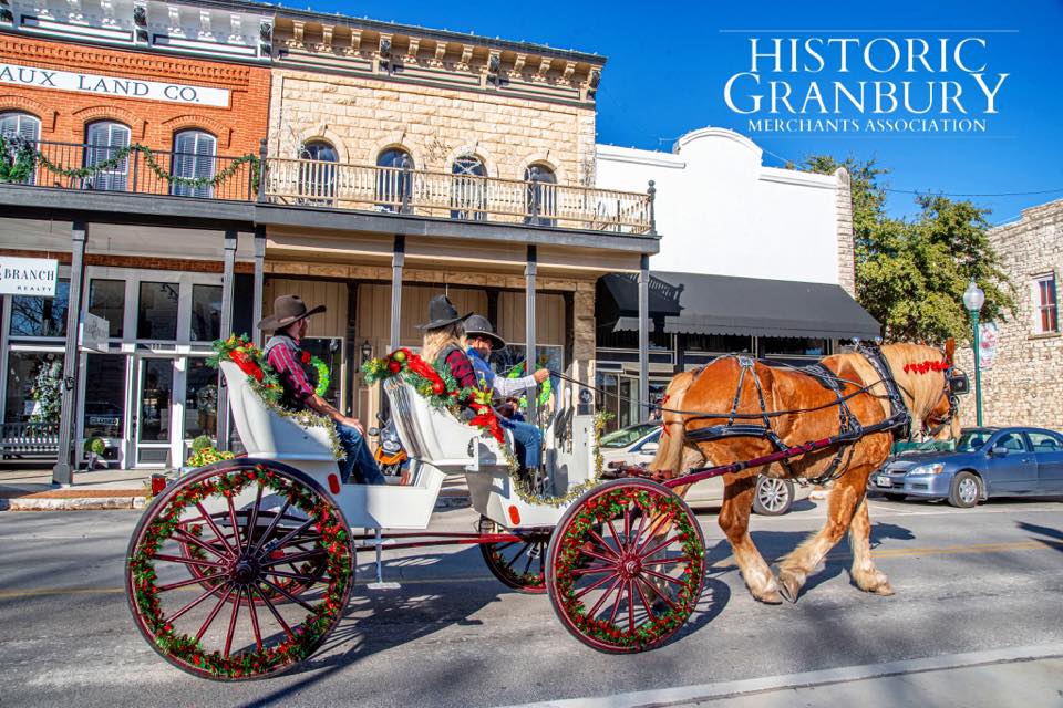 Horse-drawn carriage ride in historic Granbury, TX, adorned for the holiday season. 