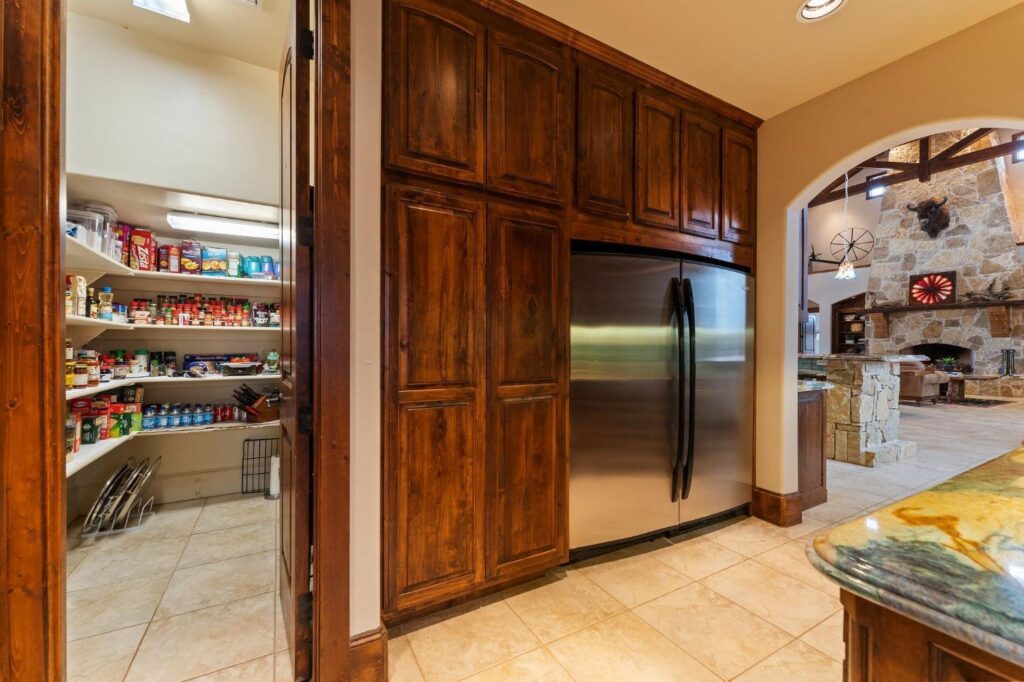 a kitchen, walk-in pantry, double door fridge, and cabinets