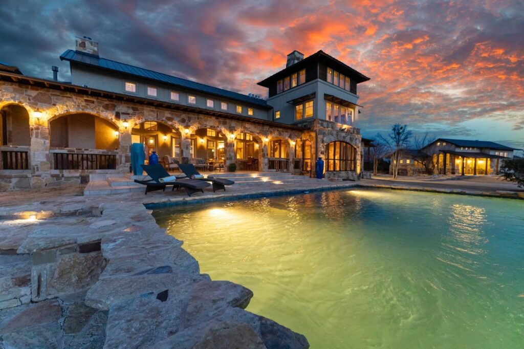 exterior of a home and pool at sunset
