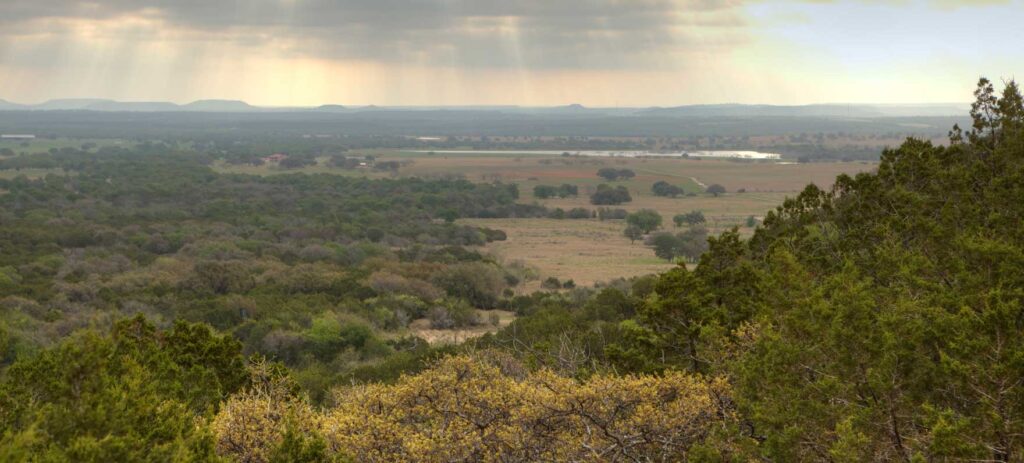 A wide shot of Palo Pinto Mountains State Park.
trees, sunlight, hills