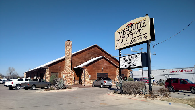Mesquite pit restaurant, cars and a building