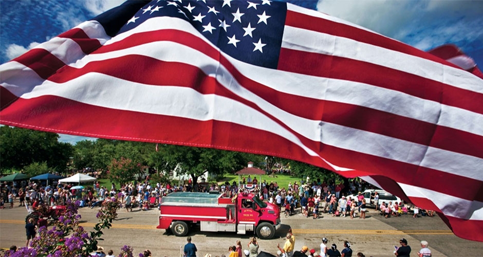 American flag over a road with a fire truck