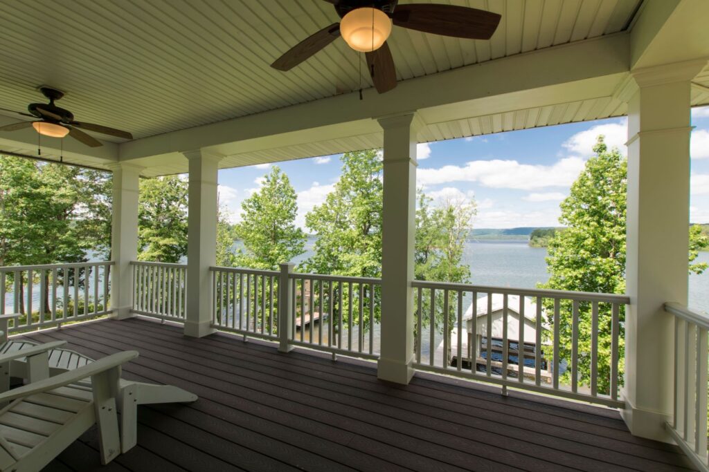 Photo of Watts Bar Lake taken from a lake home balcony featuring large white columns and wooden floors. 
