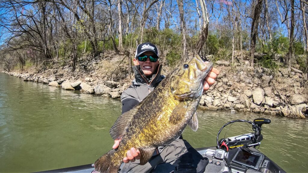 teenager holding a smallmouth bass