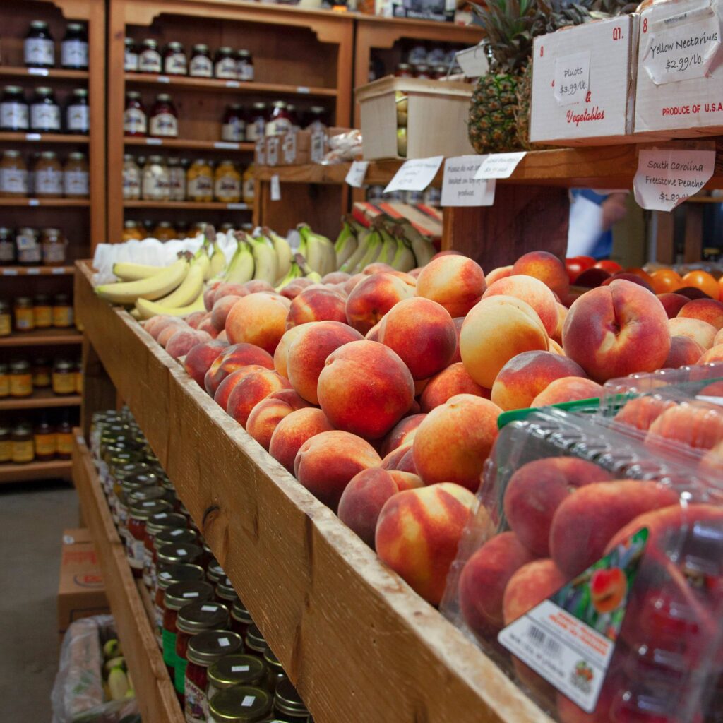 Fresh peaches and bananas with jams in the background. 