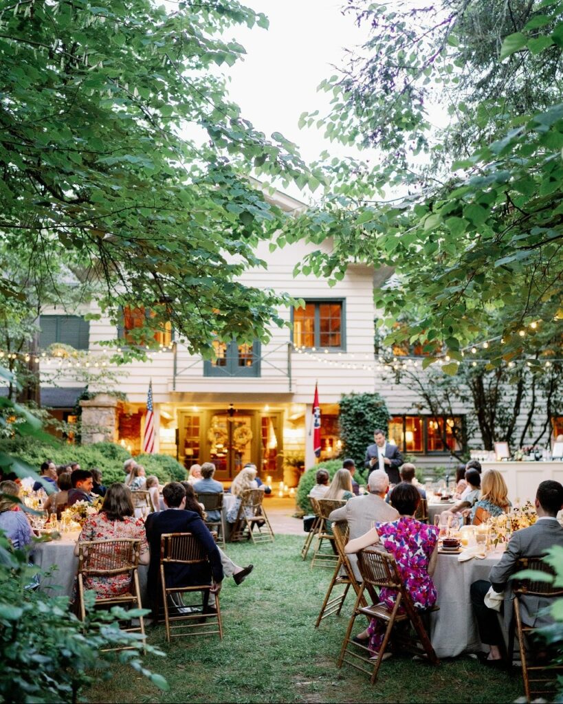 The outdoor setting at Tennessee's RT Lodge, which features white tables cloths, brown chairs, and vibrant greenery. 