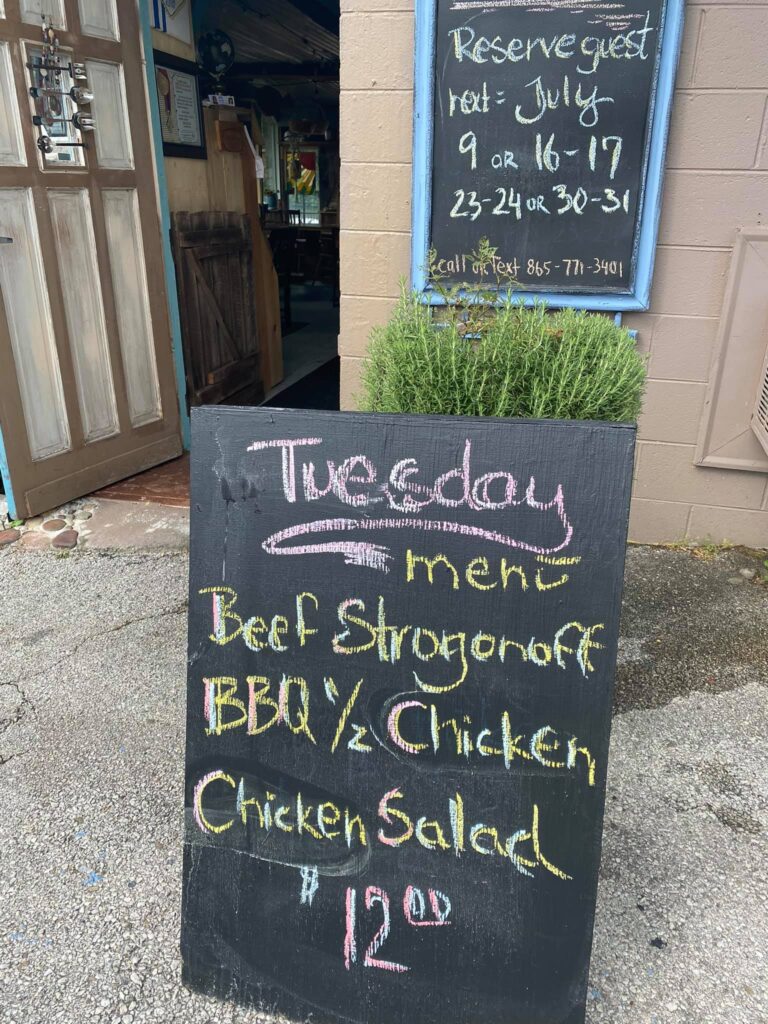Chalkboard menu for Caramella Bistro for Tuesday, featuring beef stroganoff, bbq chicken, and chicken salad