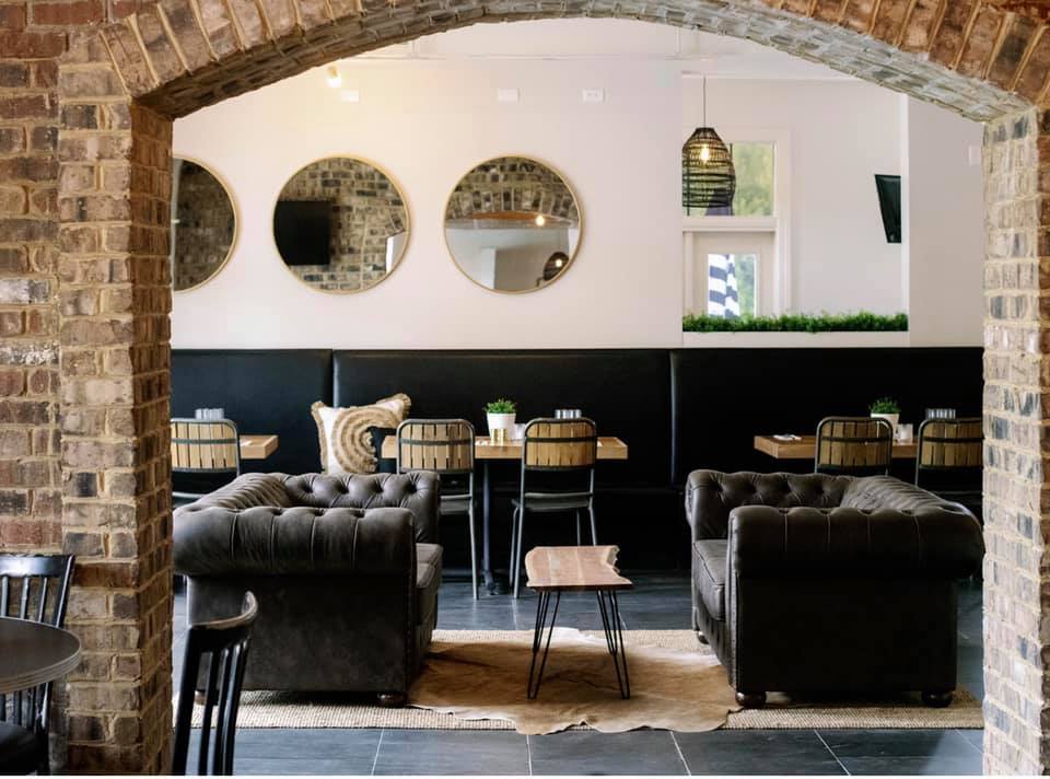 Maple Creek Bistro interiors, featuring plush chairs, mirrors, and rustic tables.