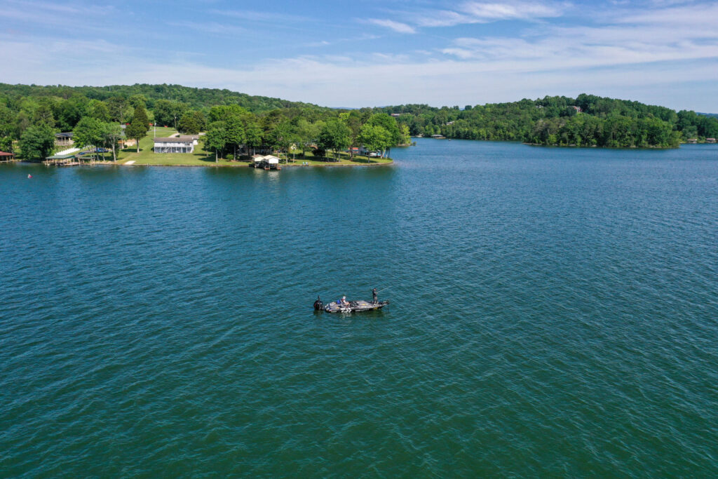 Man fishing from boat on beautiful blue waters of Watts Bar Lake. 