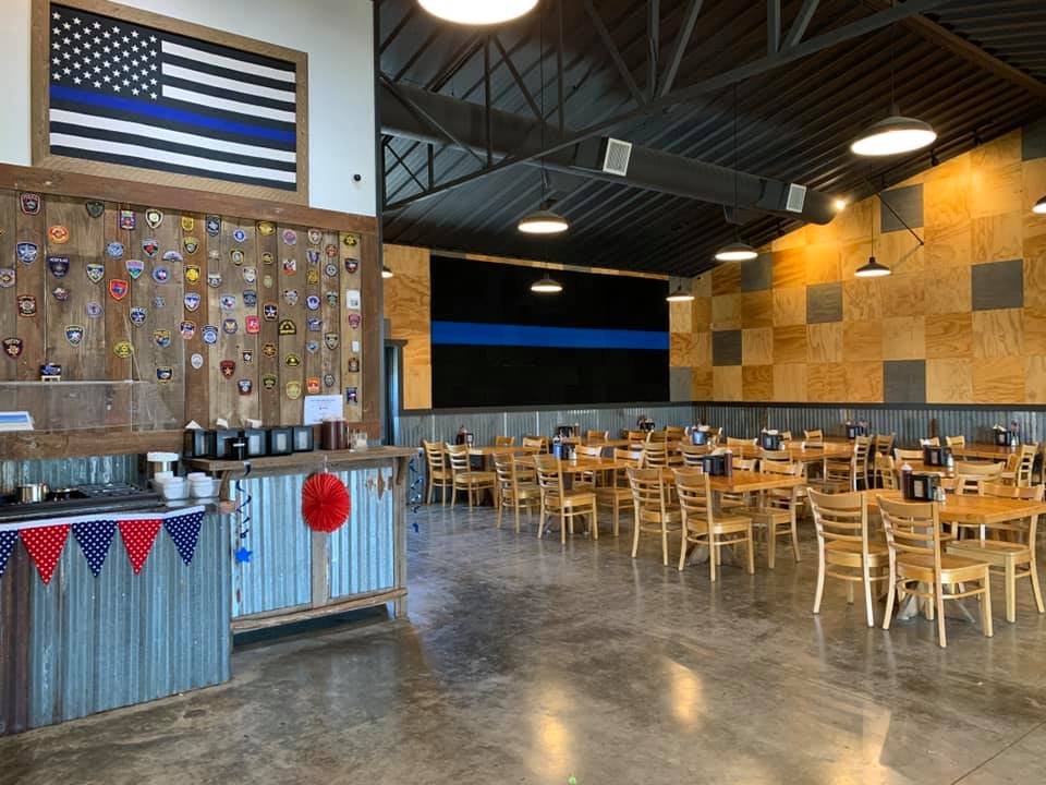 The interior of 407 BBQ in Texas, featuring concrete floors, wooden tables, and a rustic touch.