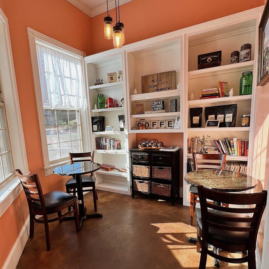 Orange walls and a book shelf filled with coffee and books---a cafe atmosphere at Uncle Mike's bistro.