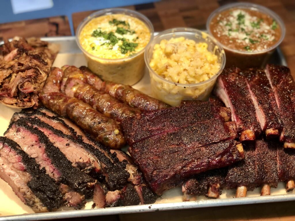 Various types of BBQ meat with sides on a meal platter.