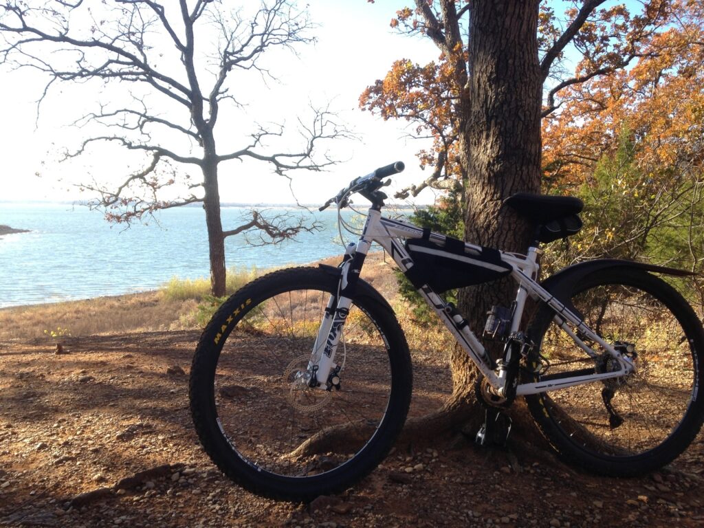 A mountain bike positioned in front of the bright blue waters of Lake Grapevine, TX.