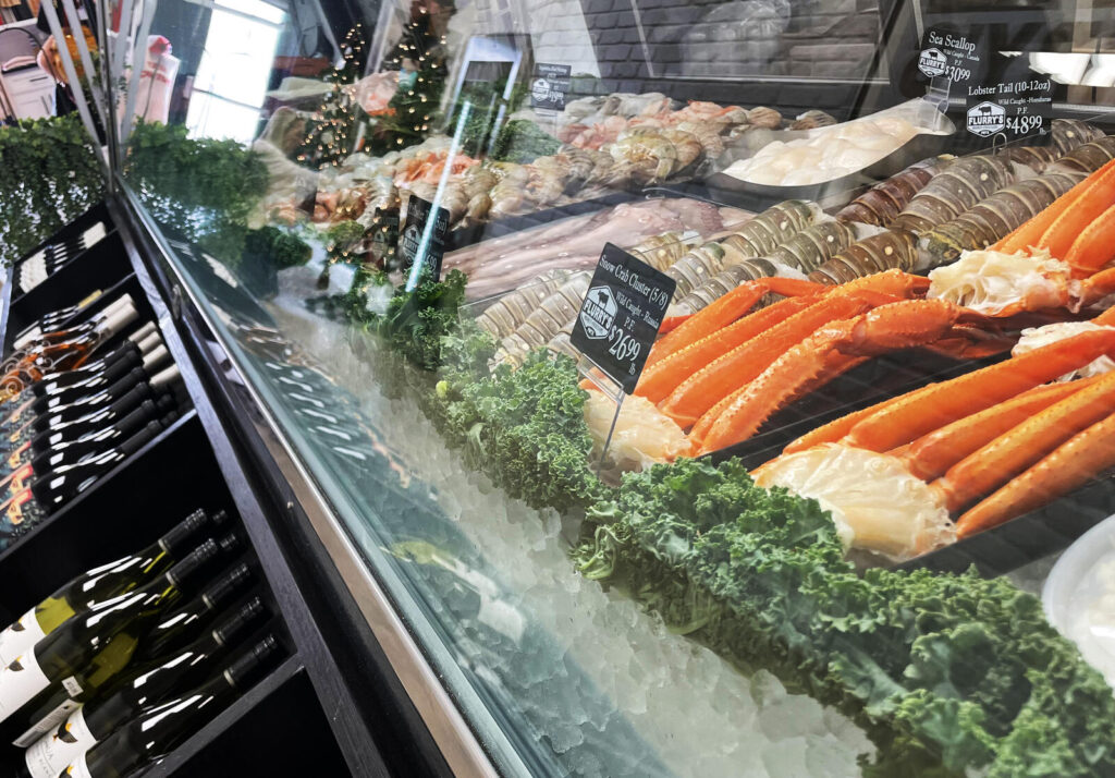 Crab legs, shrimp, and other seafood items pictured with wine at Flurry's Market + Provisions.