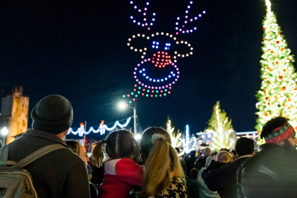 Drone show creating a reindeer as a family looks on.