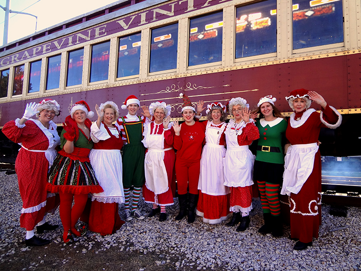 People dressed as elves in front of the iconic North Pole Express in Grapevine.