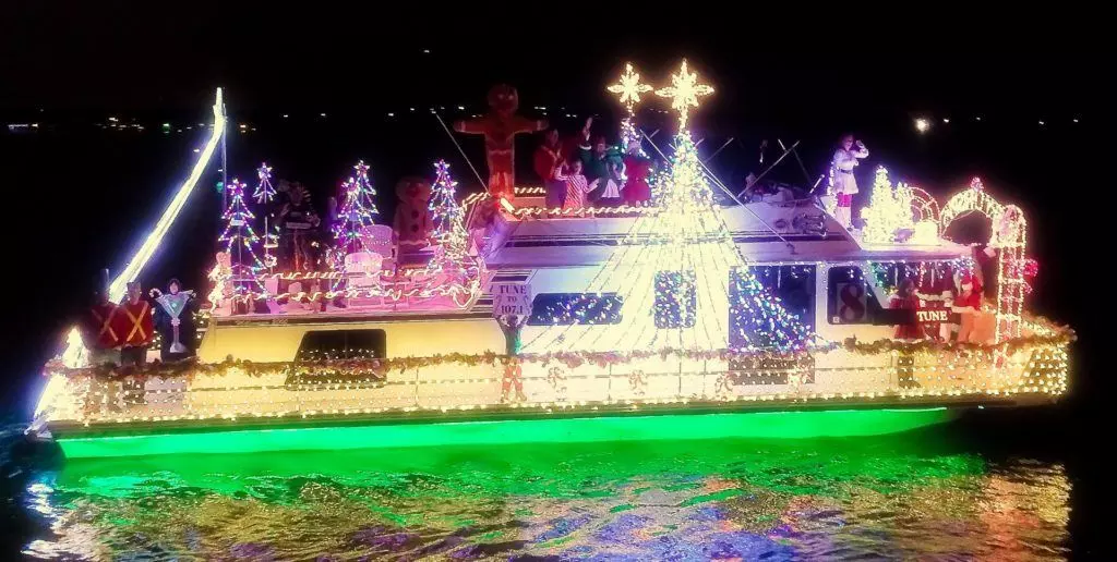Boat with twinkling lights and festive trees on Grapevine Lake.