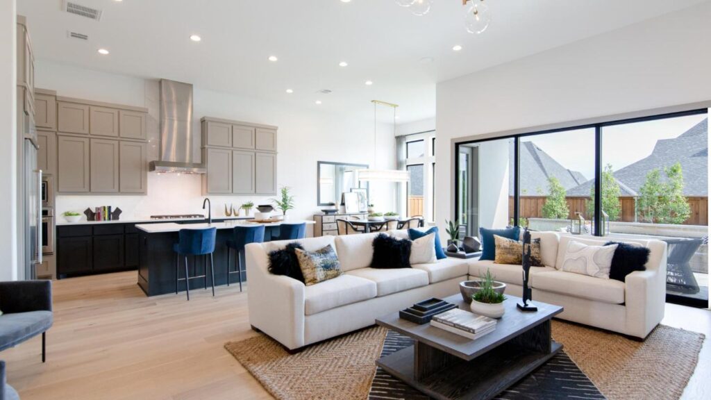 computer-generated image of a living room in front of a sleek kitchen.