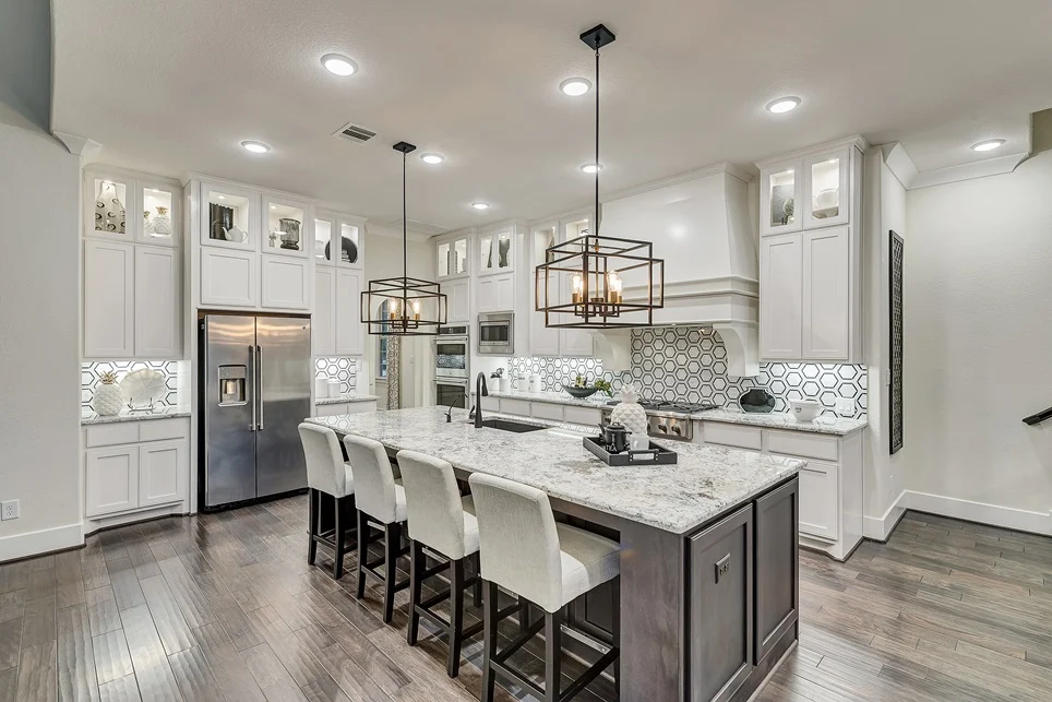 Modern kitchen with white cabinets and grey accents.