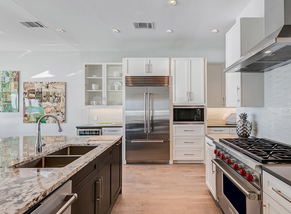 Upscale kitchen with granite countertops and white cabinets.