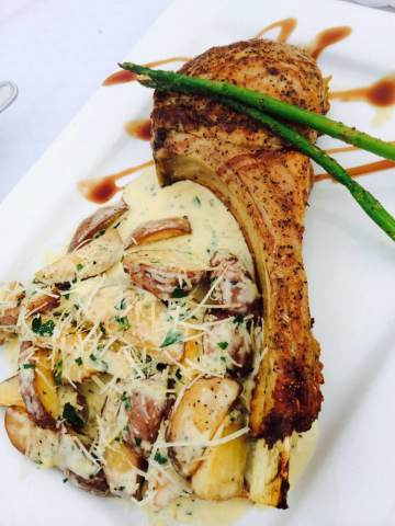 Lamb shank, potatoes, and asparagus on a plate. food