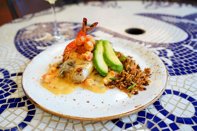 Shrimp, avocado, rice, fish, and sauce on a plate, food
