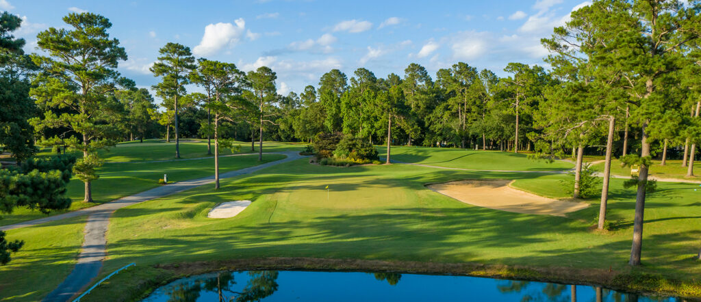 Lake Marion golf course, with a small lake, a few bunkers, and tall pine trees.