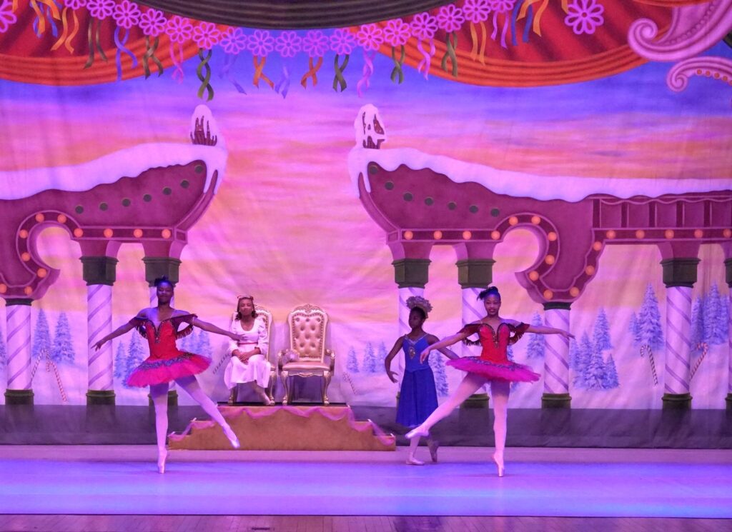 Ballet dancers in costume on a stage with a snowy background. 